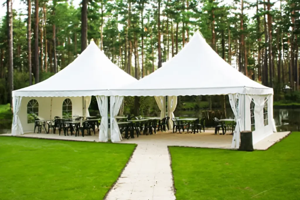 Location pagode, Tente blanche élégante de Tent’Action pour événements, installée dans un cadre extérieur serein entouré d’arbres hauts.