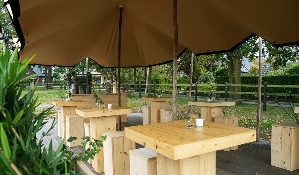 Tente nomade avec mobilier en bois brut pour événement extérieur dans les Landes